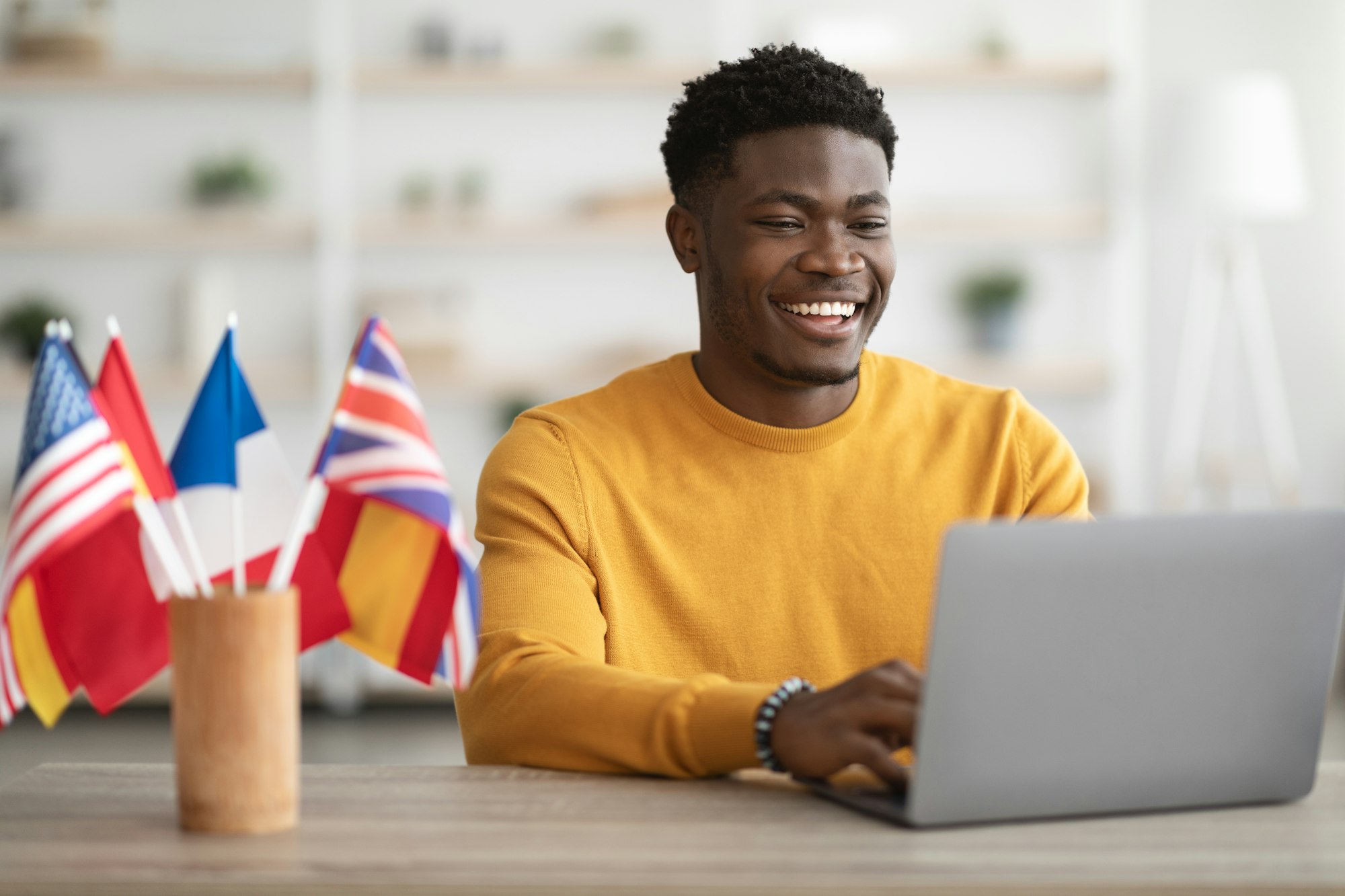 Happy black guy student studying at language school online
