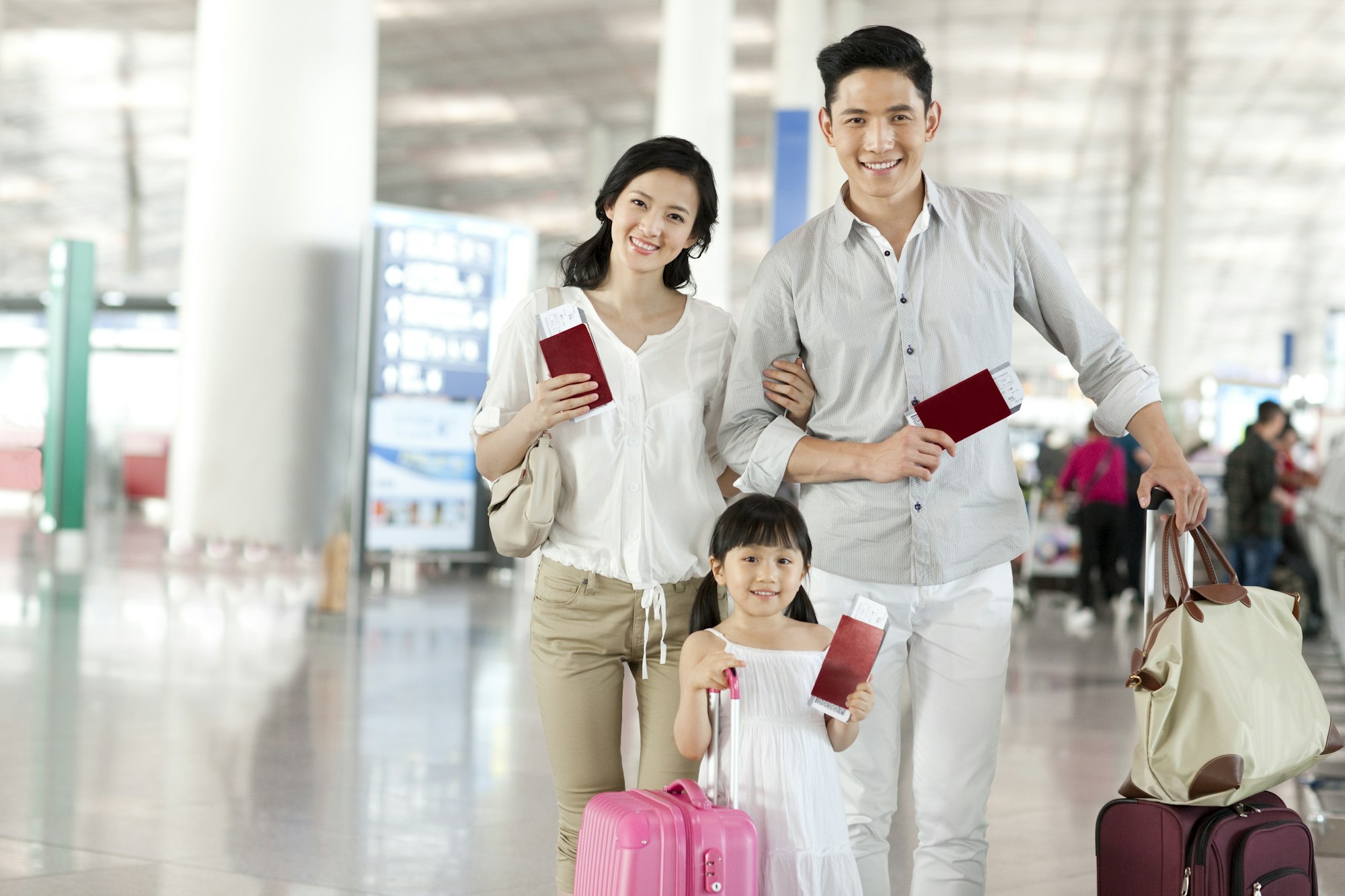 Happy young family with flight tickets and passports at the airport
