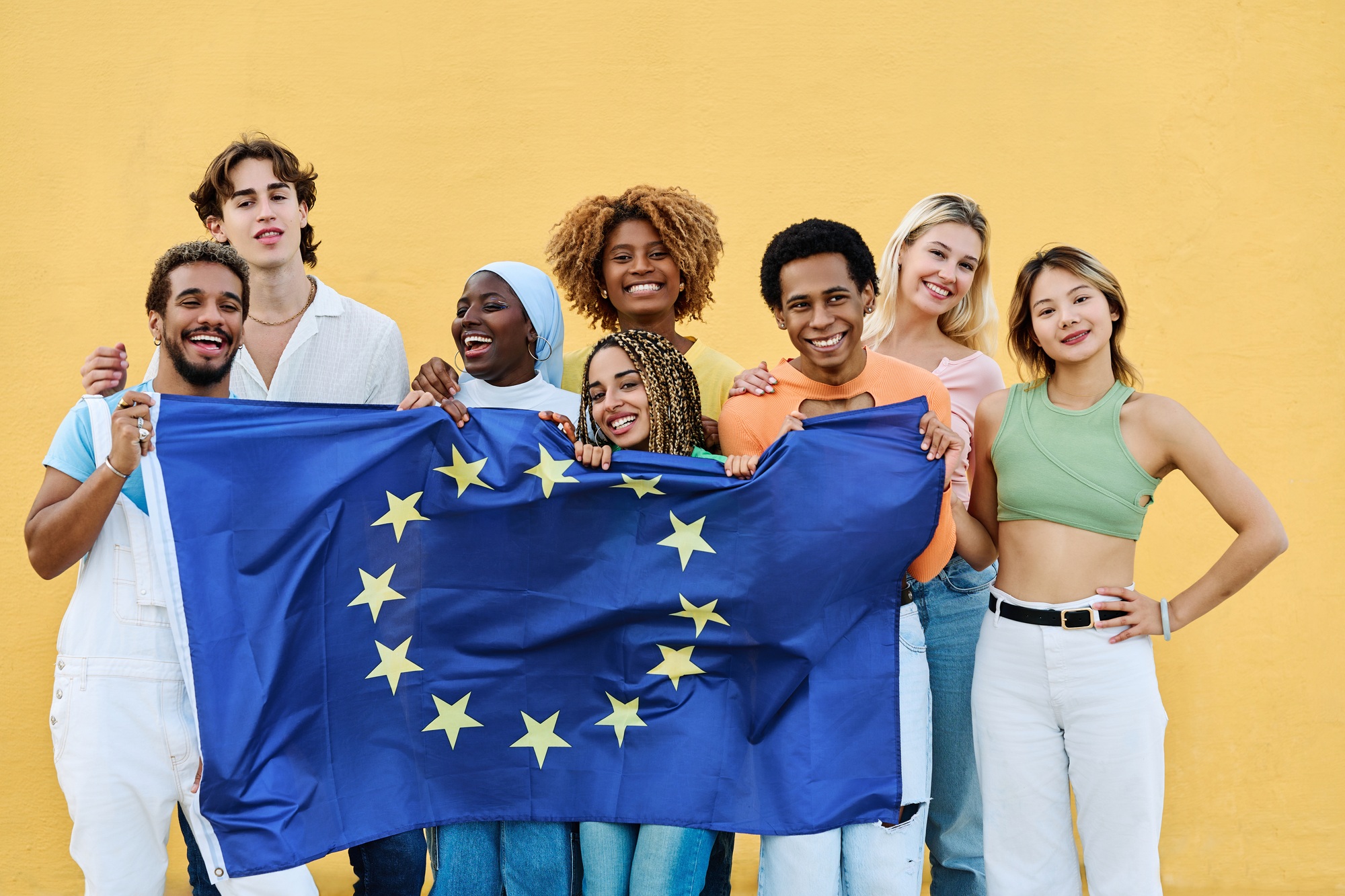 Multi-ethnic friends raising a European Union Flag