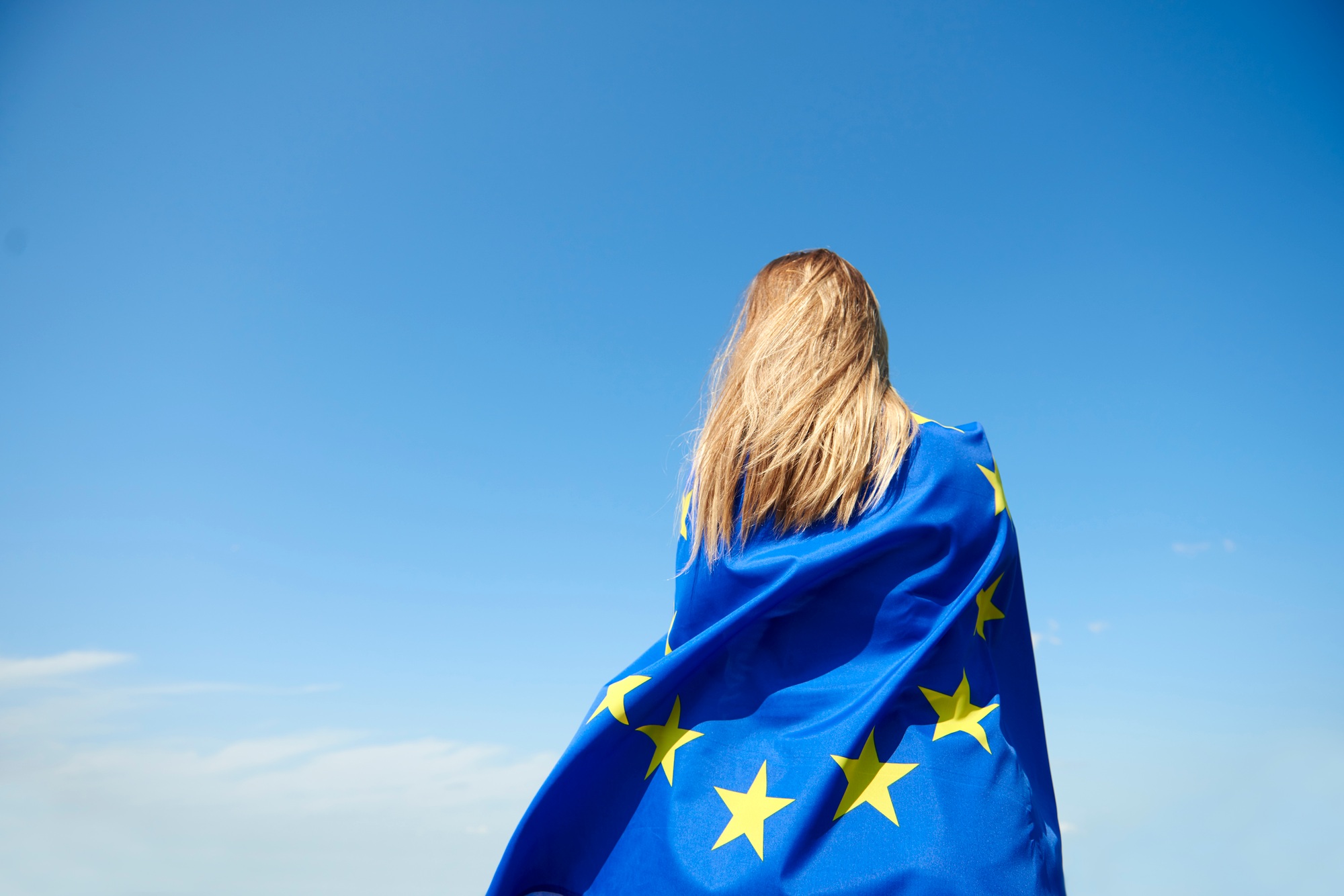 Rear view of young woman covered with European Union Flag